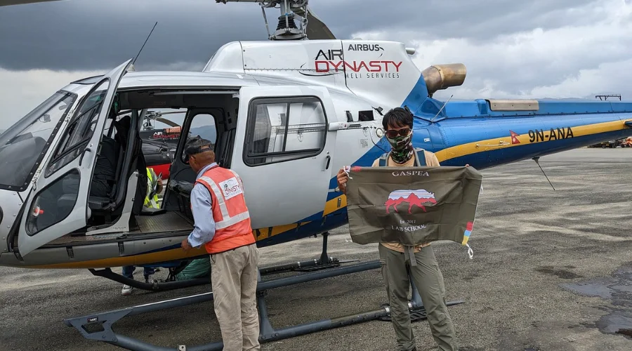 A trekker posing with the Everest helicopter