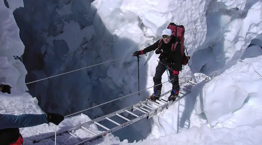 A mountaineer crossing crevasse at Khumbu Icefall