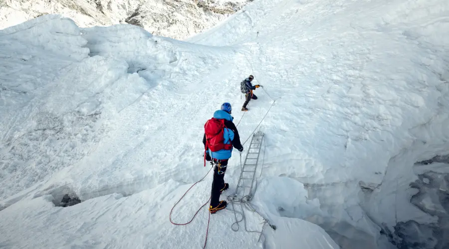 Mountaineers crossing the ladder on the Island Peak