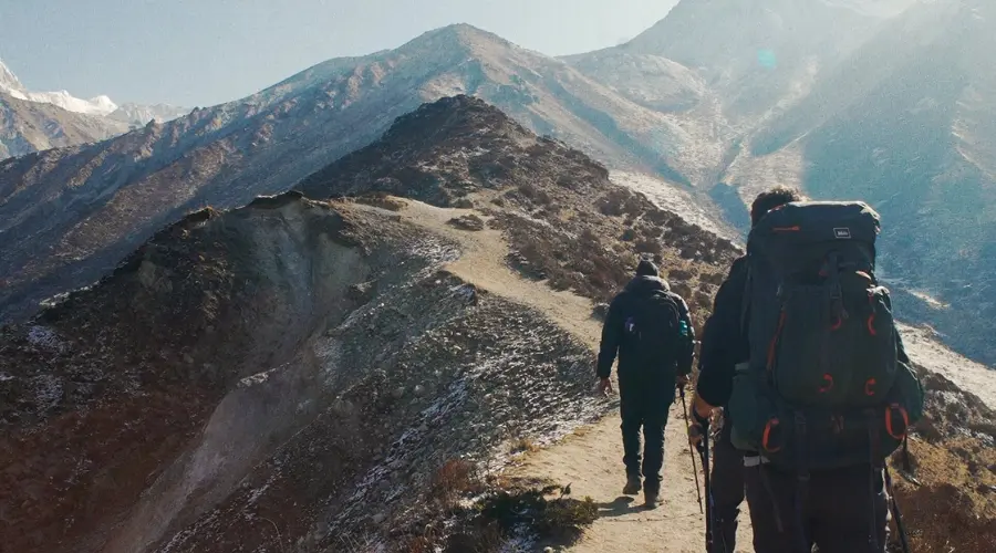 Trekkers walking on the rocky mountain edge during their trek
