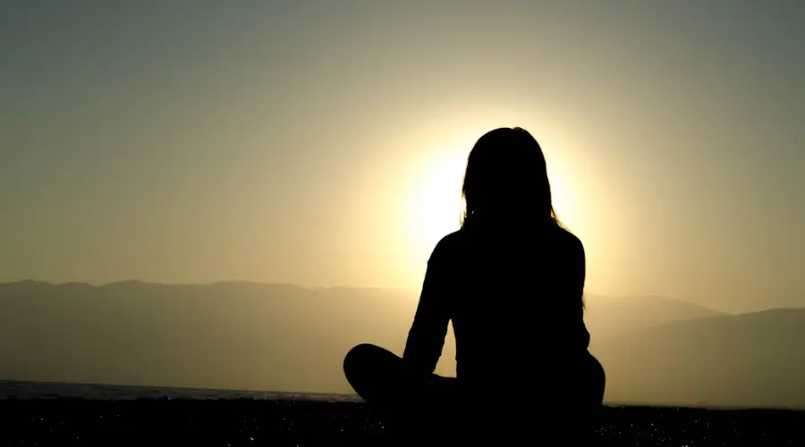 A person meditating in the morning